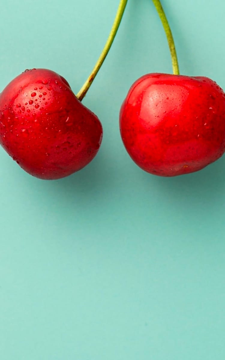 two cherries with background color light green